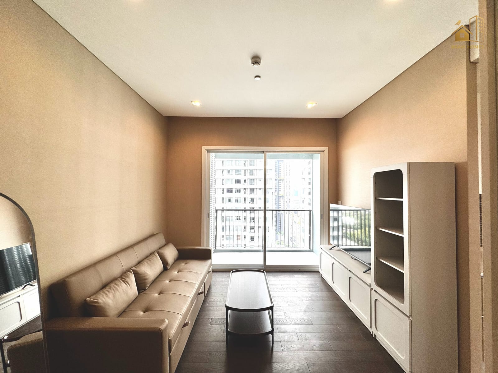 The Saint Residences ห้องใหม่ 2 นอน 64 ตร.ม. ห้องนั่งเล่น โซฟาหนังและหน้าต่างบานใหญ่