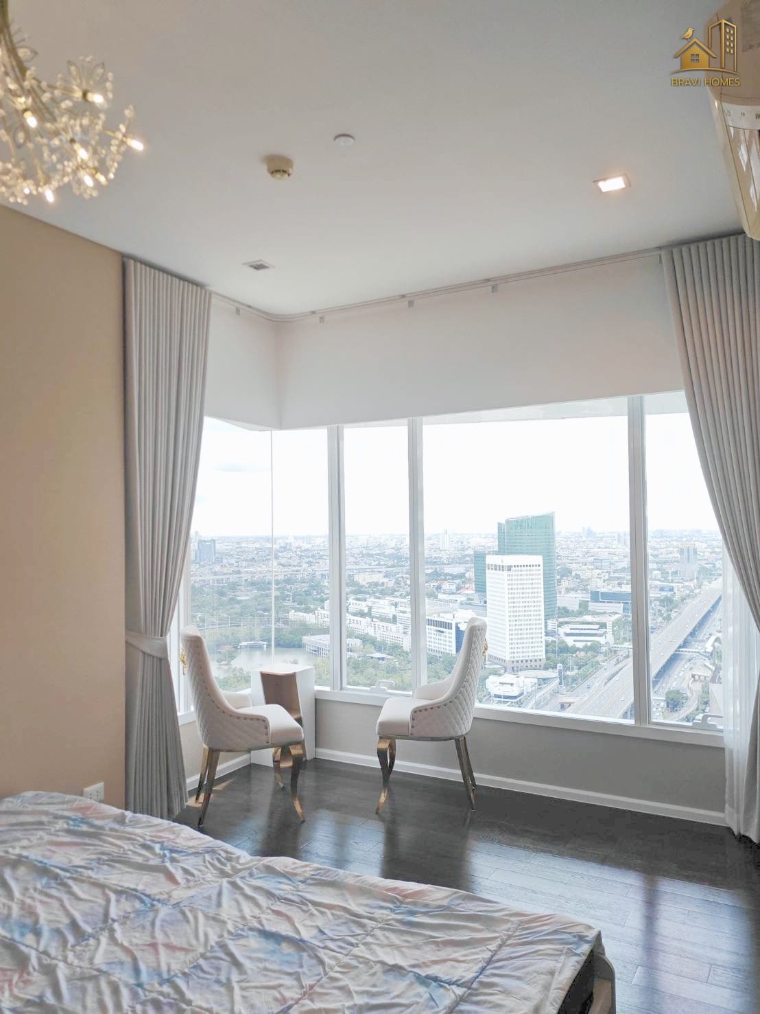 The Saint Residences 2 นอน 2 น้ำ 70.2 ตร.ม. ห้องนอนใหญ่ เตียง ชุดเก้าอี้นั่งเล่นริมหน้าต่างและวิวเมือง