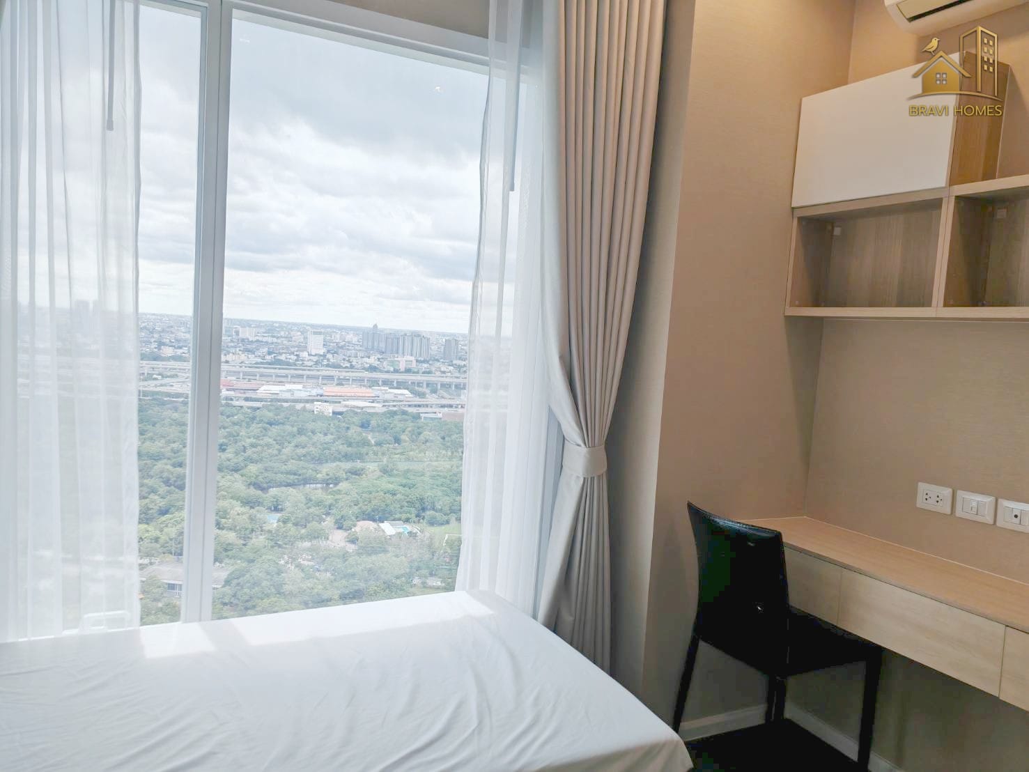 The Saint Residences 2 นอน 2 น้ำ 70.2 ตร.ม. ห้องนอนที่ 2 โต๊ะทำงาน ชั้นวางของและวิวจากหน้าต่างบานใหญ่